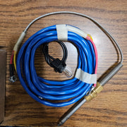 Coiled blue cable with metal probe on a wooden surface