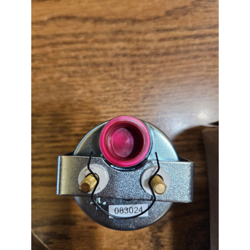 Mechanical component with pink and gold parts on a wooden surface